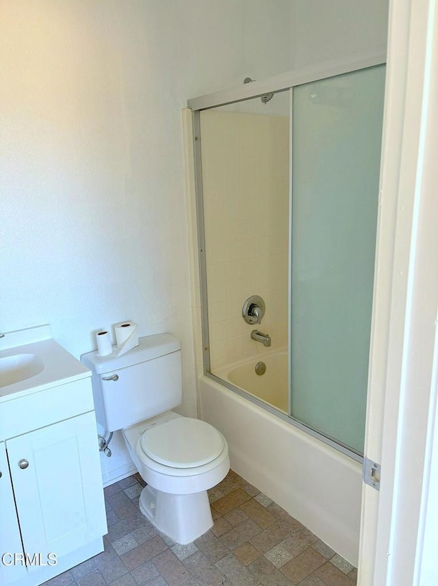 full bathroom featuring toilet, shower / bath combination with glass door, and vanity