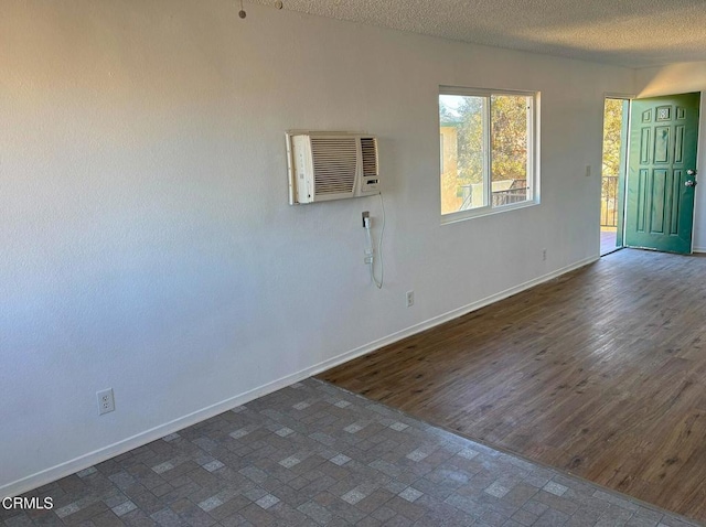 empty room featuring a textured ceiling and a wall mounted AC