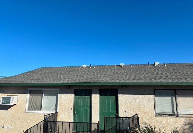 rear view of property featuring a wall mounted air conditioner