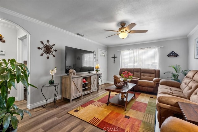 living room featuring ceiling fan, wood-type flooring, and ornamental molding