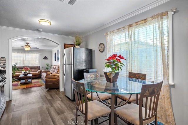 dining area with ceiling fan, crown molding, and hardwood / wood-style floors