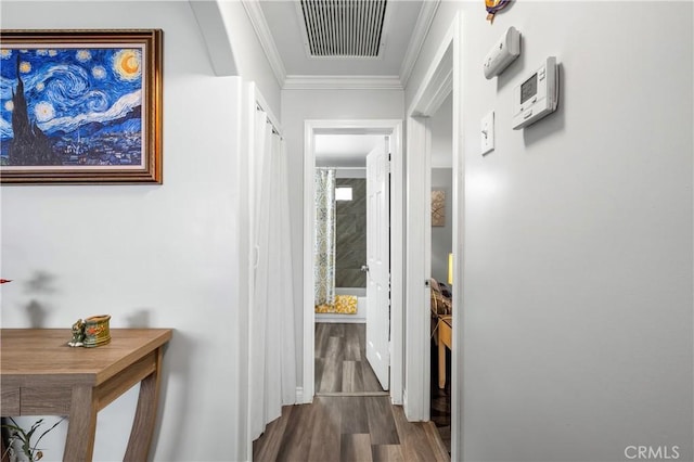 corridor with dark wood-type flooring and crown molding