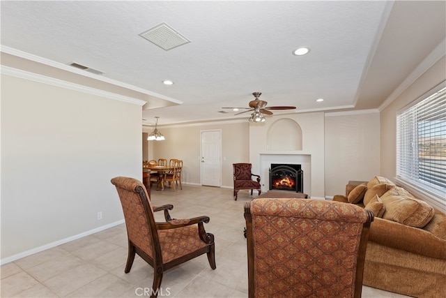 living room featuring crown molding, a textured ceiling, and ceiling fan