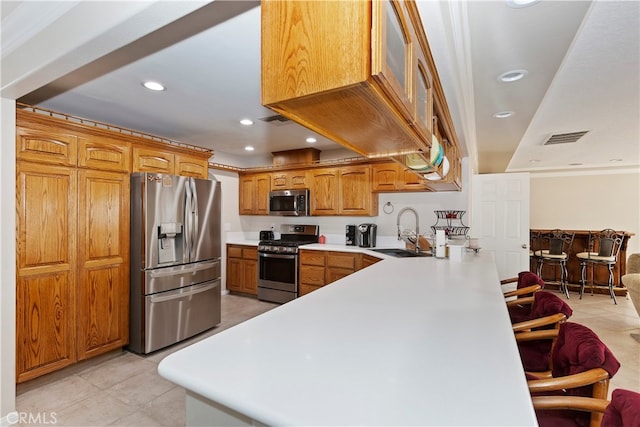 kitchen with sink, appliances with stainless steel finishes, and kitchen peninsula