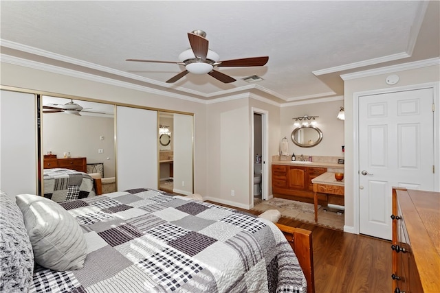 bedroom featuring hardwood / wood-style floors, connected bathroom, ceiling fan, and ornamental molding