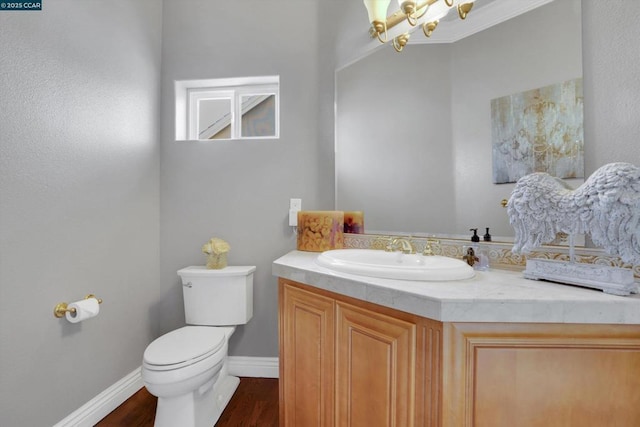 bathroom with hardwood / wood-style floors, vanity, an inviting chandelier, toilet, and crown molding