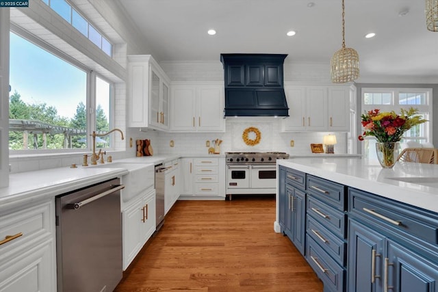 kitchen with blue cabinets, stainless steel appliances, tasteful backsplash, and decorative light fixtures