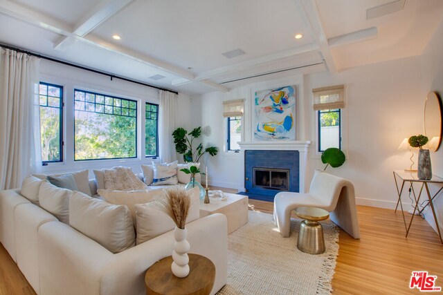 living room with coffered ceiling, light hardwood / wood-style floors, and beam ceiling