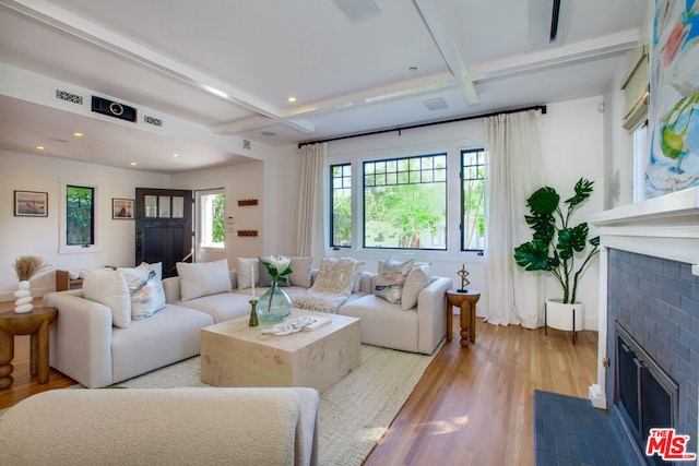 living room with coffered ceiling, beamed ceiling, light hardwood / wood-style floors, and a fireplace