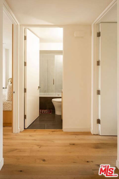 hallway with hardwood / wood-style flooring