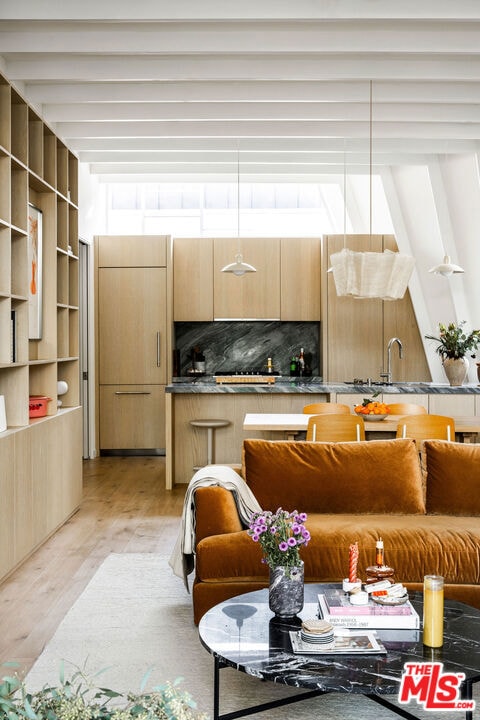 living room featuring sink and light hardwood / wood-style flooring