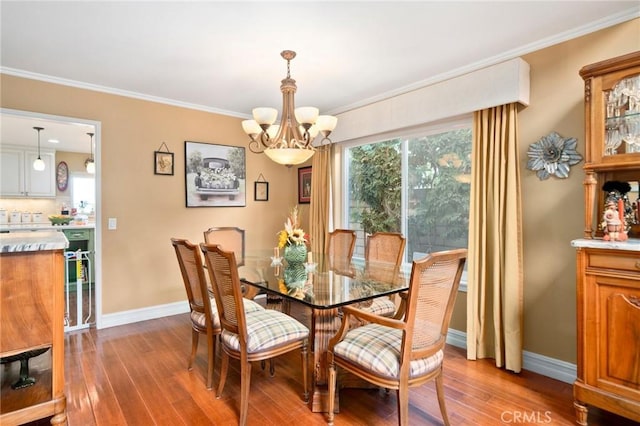 dining space featuring crown molding, hardwood / wood-style floors, and an inviting chandelier