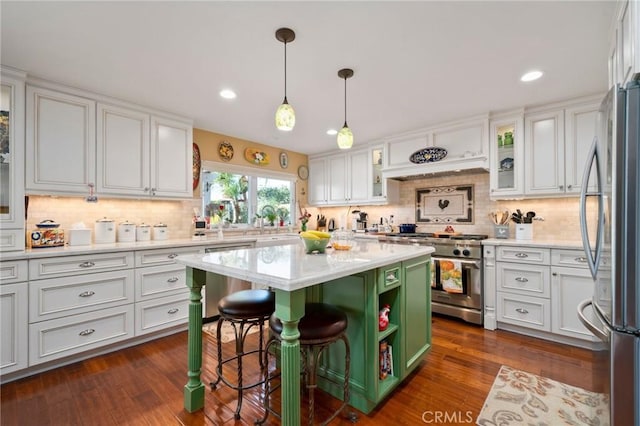 kitchen with a breakfast bar area, stainless steel appliances, white cabinets, and a kitchen island