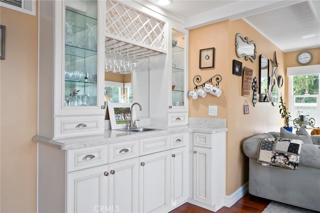 bar featuring crown molding, dark hardwood / wood-style floors, sink, and white cabinets