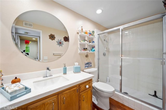 bathroom with vanity, an enclosed shower, hardwood / wood-style floors, and toilet