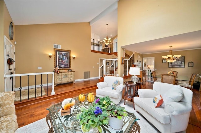 living room with an inviting chandelier, wood-type flooring, and high vaulted ceiling