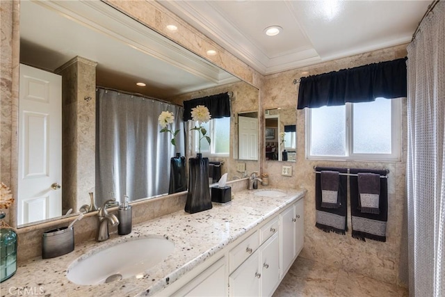 bathroom with ornamental molding, vanity, and a wealth of natural light