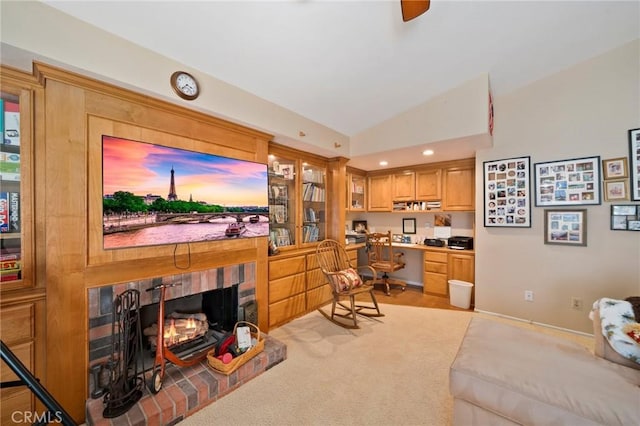 living room featuring vaulted ceiling, built in desk, light colored carpet, and a fireplace