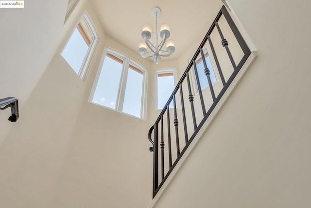 stairs with an inviting chandelier