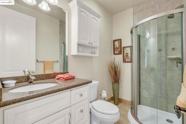 bathroom with vanity, a shower with shower door, tile patterned floors, and toilet