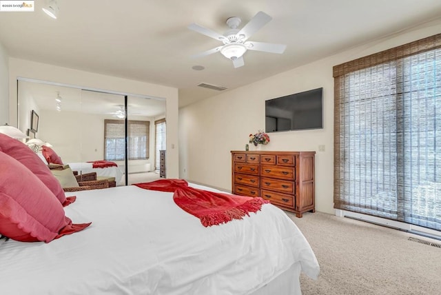 carpeted bedroom featuring ceiling fan and a closet