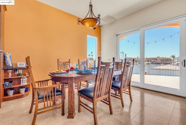 tiled dining room featuring a water view