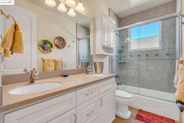 full bathroom with bath / shower combo with glass door, toilet, and vanity