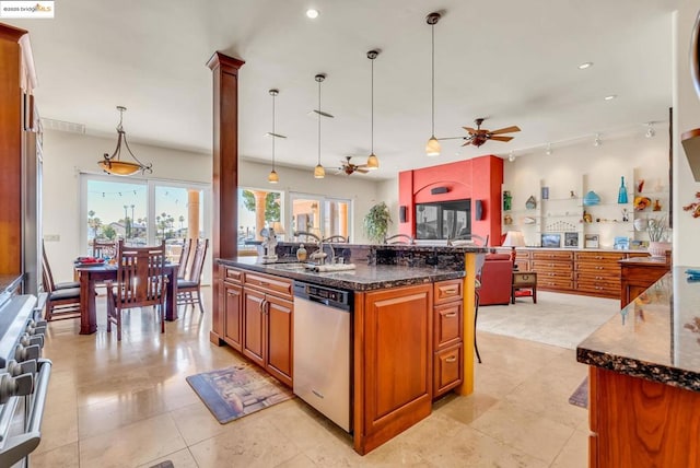 kitchen with stainless steel appliances, dark stone countertops, sink, hanging light fixtures, and a center island with sink