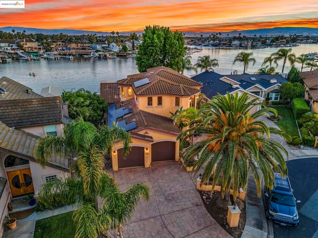 aerial view at dusk featuring a water view