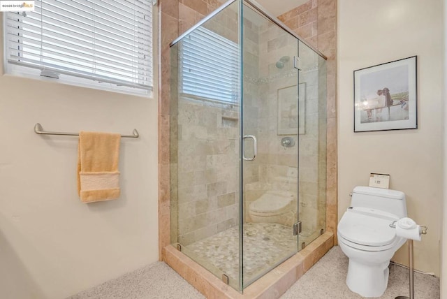 bathroom featuring toilet and an enclosed shower