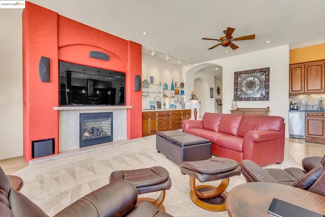 carpeted living room featuring ceiling fan, bar area, and track lighting