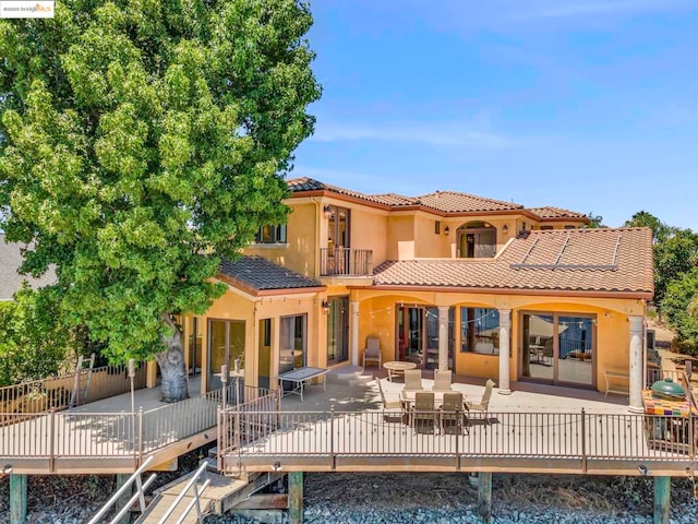 rear view of property featuring a balcony and a patio