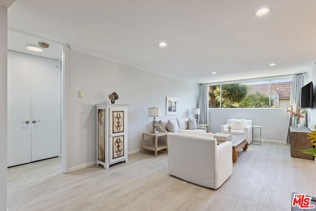 living room with light wood-type flooring and ornamental molding