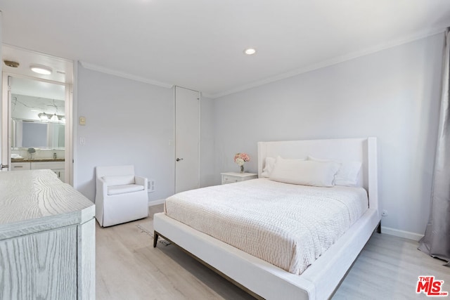 bedroom with light hardwood / wood-style floors and crown molding