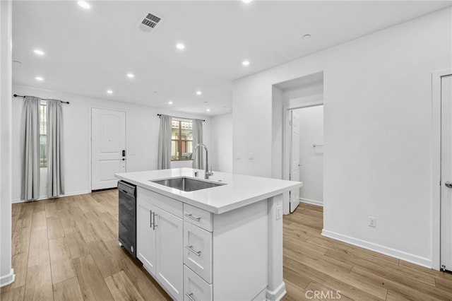 kitchen with sink, a center island with sink, light hardwood / wood-style floors, and white cabinetry