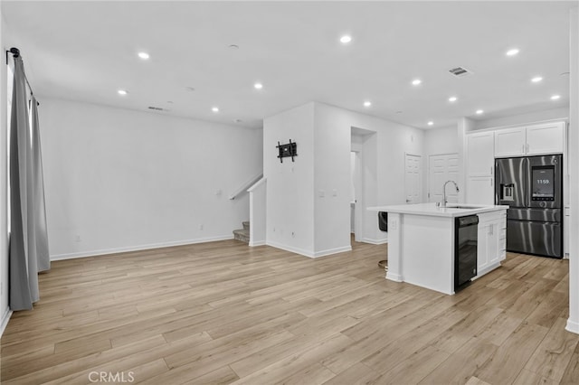 kitchen featuring stainless steel fridge with ice dispenser, an island with sink, light hardwood / wood-style flooring, and sink