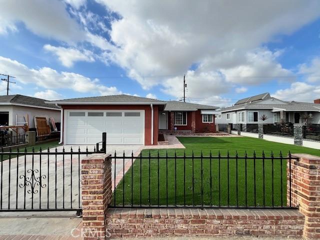 ranch-style home featuring a garage and a front lawn