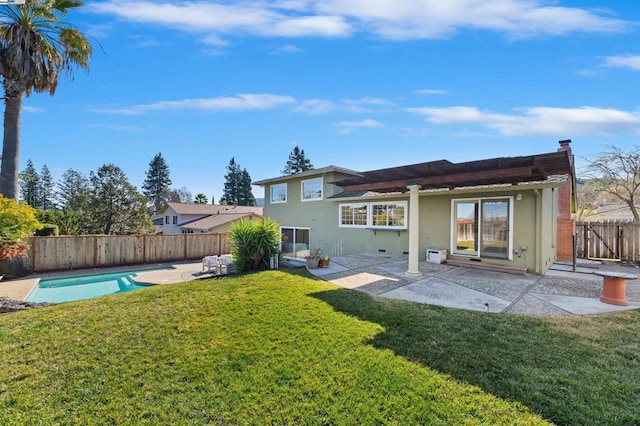 back of house with a yard and a patio