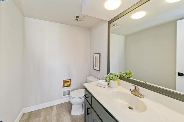 bathroom with vanity, wood-type flooring, and toilet