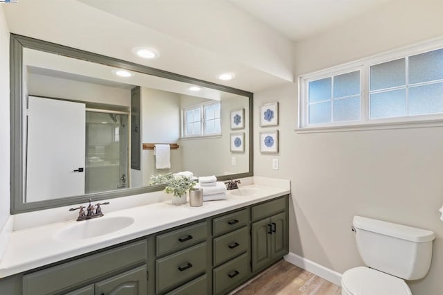 bathroom with vanity, a wealth of natural light, wood-type flooring, and walk in shower