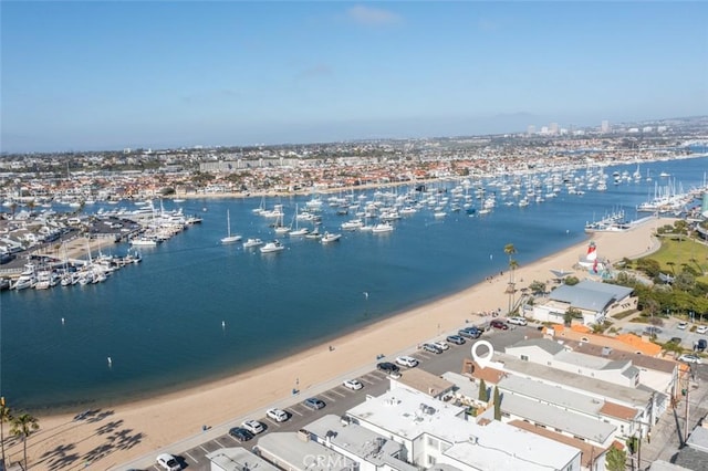 birds eye view of property with a water view and a beach view