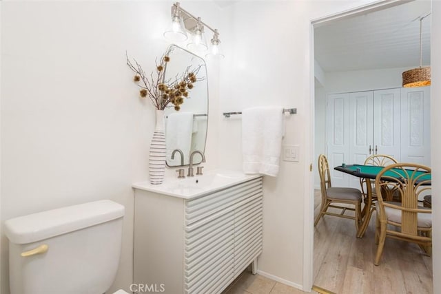 bathroom with hardwood / wood-style floors, toilet, and vanity