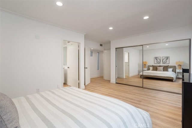 bedroom with a closet, hardwood / wood-style flooring, and ornamental molding