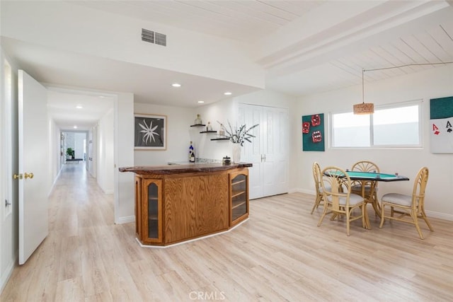 bar with light wood-style floors, a dry bar, baseboards, and visible vents