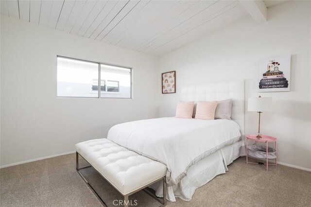 carpeted bedroom featuring lofted ceiling with beams and wood ceiling