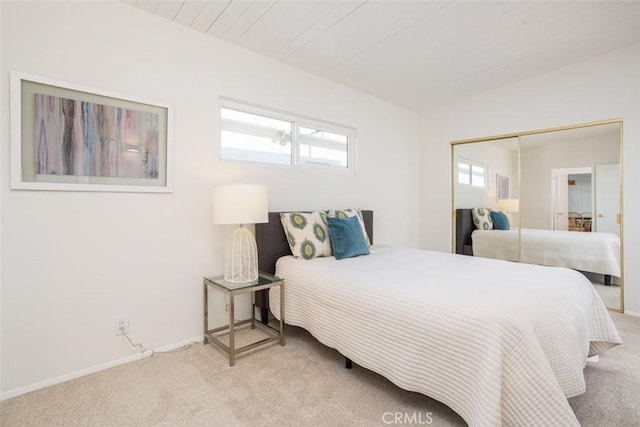 carpeted bedroom with a closet and baseboards