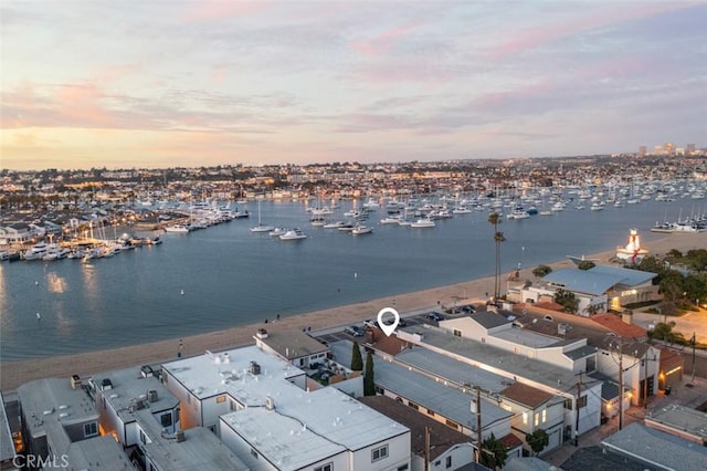 aerial view at dusk featuring a water view