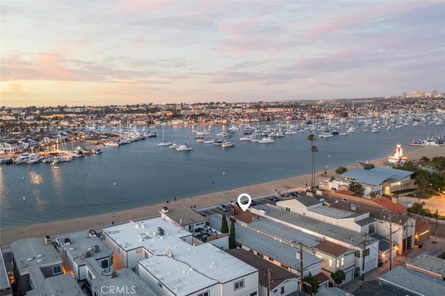 aerial view at dusk featuring a water view