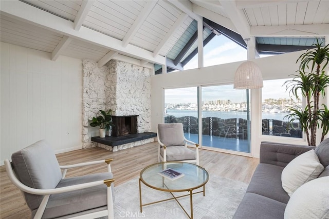 sunroom featuring a water view and beamed ceiling
