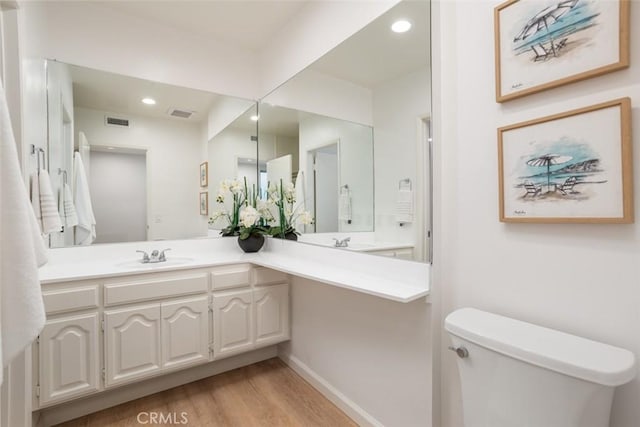 bathroom with vanity, visible vents, recessed lighting, toilet, and wood finished floors